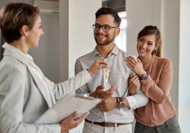 Família feliz reunida utilizando o mesmo celular sentados no sofá